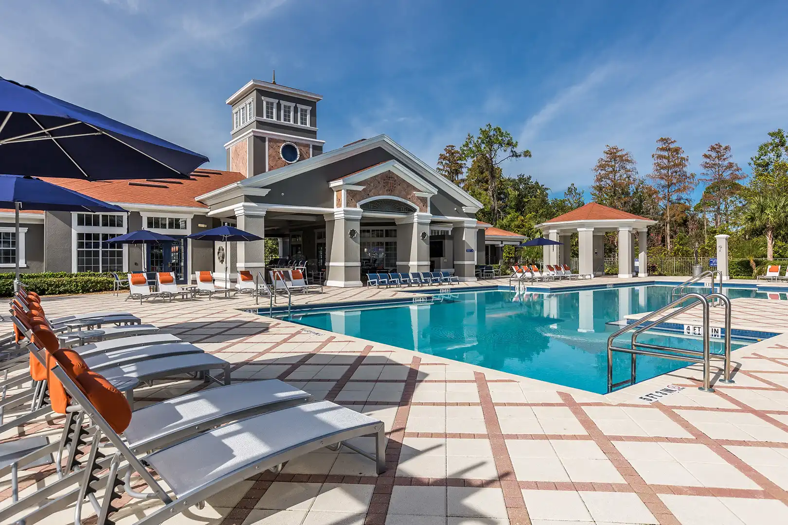 pool with lounge chairs and view of community building