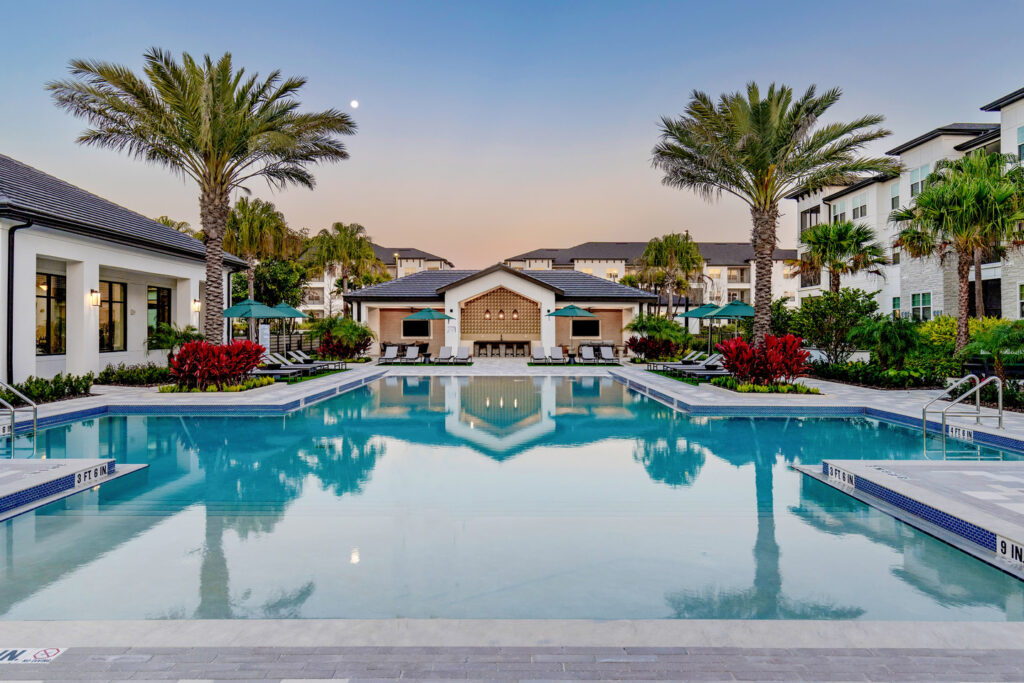 pool with lounge chairs and outdoor kitchen