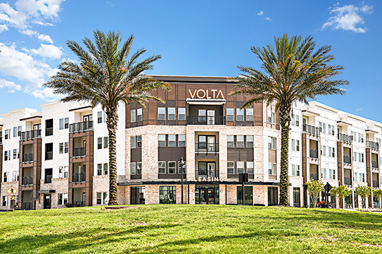 Apartment building with palm trees on each side of the building.